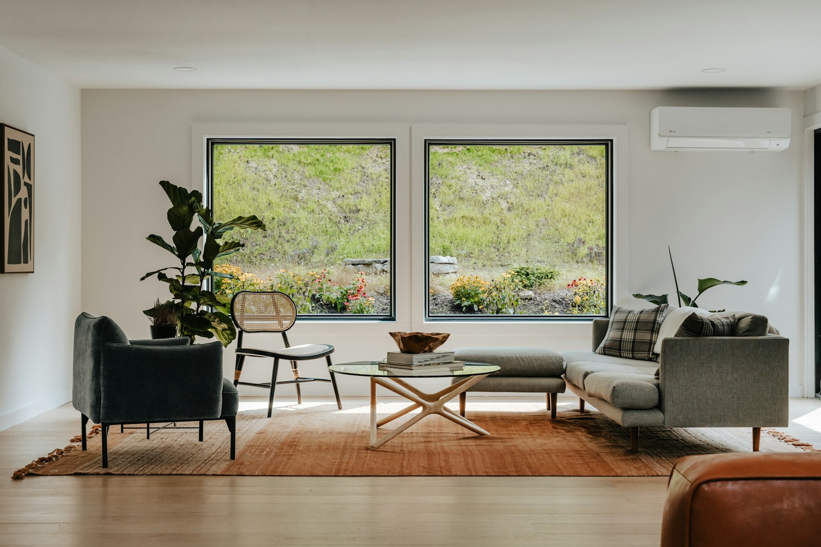A modern living room with large, freshly cleaned windows framing a green view