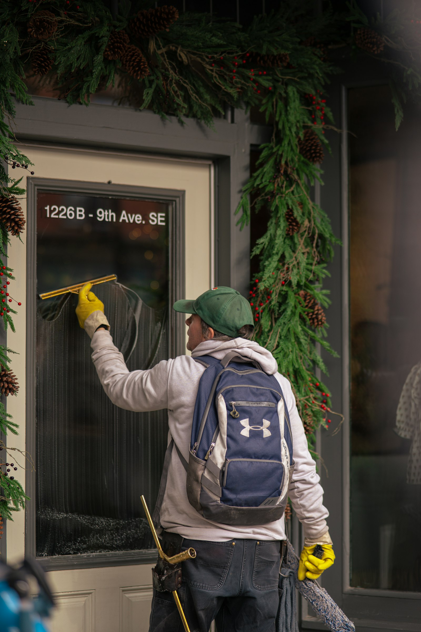 A window cleaner cleaning a glass door with a squeegee